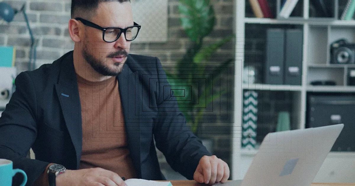 A brunette woman sitting at a desk with a laptop, smiling in an elegant office setting. — Foto: Helena Lopes / Pexels