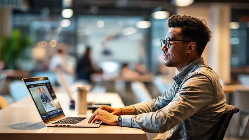 A photorealistic image of a digital nomad sitting calmly in a vibrant co-working space, with a timer on their desk next to a laptop displaying an online course. The background shows blurred but energetic activity, highlighting focus amidst movement. Cinematic lighting, sharp focus on the nomad and timer, depth of field blurring the background. 8K hyper-detailed, professional photography, shot on a high-end DSLR.
